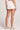 Back view of a woman wearing the Saltwater Luxe Arabella salt white shorts on a plain background