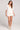 Front cropped view of a woman wearing the Saltwater Luxe Arabella salt white shorts with matching Leyah top on a plain background