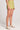 Side view of a woman wearing the Saltwater Luxe light green Arabella Willow Short on a plain background