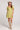 Front view of a woman wearing the Saltwater Luxe green Eldoris Willow Mini Dress with beige boots and a white hat on a plain background