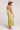 Back view of woman wearing the Saltwater Luxe green Anaya Willow Midi Dress and straw hat on a white background