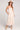 Front view of a woman wearing the Saltwater Luxe Camrie Midi Dress in beige and straw hat on a plain background