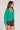 Saltwater Luxe Ellyn Sweater green cardigan shown from the side layered over a black top with denim shorts against a plain background