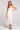 Front view of a woman wearing the Saltwater Luxe Elowena Salt White Midi Dress on a plain background