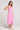 Side view of a woman wearing wearing the Saltwater Luxe Elowena Dahlia Pink Midi Dress against a plain background