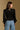 Model wearing the Saltwater Luxe Briella Black Top with a square neckline, gathered sleeves and fitted bodice, back view
