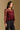 Model wearing the Saltwater Luxe Korrey Burgundy Top with a ruffled hem, side view