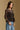 Model wearing the Saltwater Luxe Korrey Black Top with a ruffled hem, side view