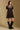 Model wearing the Saltwater Luxe Yaz Black Mini Dress with short puff sleeves, side view