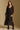 Model wearing the Saltwater Luxe Cyris Midi Dress in Black with a flowing skirt, front view