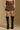 Model wearing the Saltwater Luxe Corin Mini Skirt in Chocolate showing chocolate faux-leather mini skirt, front view
