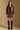 Model wearing the Saltwater Luxe Corin Mini Skirt in Chocolate showing chocolate faux-leather mini skirt, full-body view