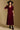 Model wearing the Saltwater Luxe Lorin Midi Dress in Burgundy with a flowing skirt, front view
