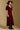 Model wearing the Saltwater Luxe Lorin Midi Dress in Burgundy with a flowing skirt, side view