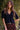 Model wearing the Saltwater Luxe Aeris Black Sweater showing black short-sleeve V-neck button-front sweater, editorial view