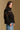 Model wearing the Saltwater Luxe Orian Black Jacket with small allover motifs, side view