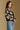Model wearing the Saltwater Luxe Calian Sweater in Black with contrast cream flowers, side view