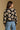 Model wearing the Saltwater Luxe Calian Sweater in Black with contrast cream flowers, back view