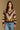 Model wearing the Saltwater Luxe Kaye Sweater multi striped V-neck sweater in brown, cream and olive, front view