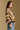 Model wearing the Saltwater Luxe Kaye Sweater multi striped V-neck sweater in brown, cream and olive, side view