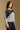 Model wearing the Saltwater Luxe Crue Vintage Blue Sweater with charcoal and cream diagonal panels, side view