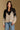 Model wearing the Saltwater Luxe Cain Natural Sweater with black colorblocking and chevron knit detail, front view