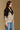 Model wearing the Saltwater Luxe Cain Natural Sweater with black colorblocking and chevron knit detail, side view
