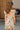 Girl model wearing Saltwater Luxe Littles Brammie Girls Mini Dress in Blue Floral back view with open back detail outdoors