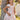 Girl model wearing Saltwater Luxe Littles Sophia Mini Dress in Cream Floral standing outdoors by tree