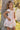 Girl model wearing Saltwater Luxe Littles Sophia Mini Dress in Cream Floral standing outdoors by tree