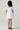 Girl model wearing Saltwater Luxe Littles Allima Girls Mini Dress in Blue Floral back full body studio view on grey background