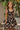 Girl model wearing Saltwater Luxe Littles Kayler Girls Mini Dress in Black Shell Print standing outdoors near lemon tree