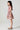 Side profile of girl wearing the Sophia Mini Dress in a blush floral print with smocked bodice and flutter sleeves