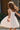 Girl model wearing Saltwater Luxe Littles Kayler Girls Mini Dress in White Eyelet twirling outdoors with embroidered scalloped hem