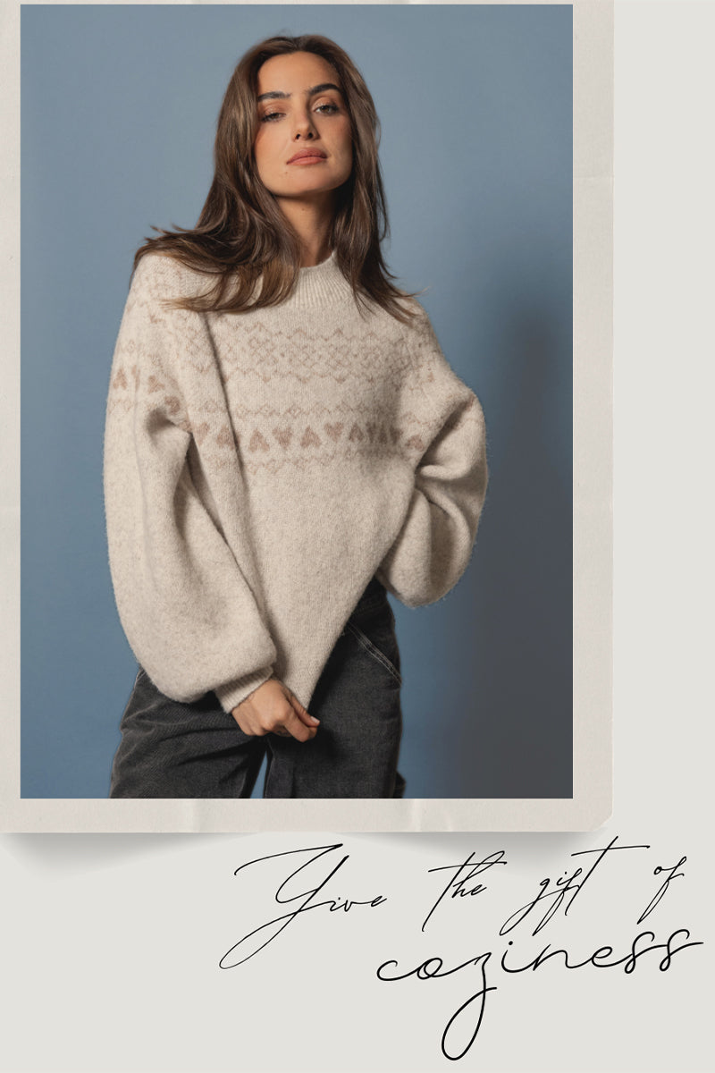 Woman wearing a cozy sweater with a plain background and text overlay promoting Saltwater Luxe's Holiday Gift Guide