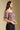 Side angle view of a woman wearing the Saltwater Luxe Robyn Top on a neutral background with pants