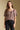 Front view of a woman wearing the Saltwater Luxe Robyn Top on a neutral background with black pants