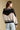 Back view of a woman wearing the Saltwater Luxe Azure Sweater on a neutral background with jeans