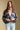 Front view of a woman wearing the Saltwater Luxe Aden Sweater on a neutral background with hands clasped at bodice 
