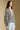 Side angle view of a woman wearing the Saltwater Luxe Aden Sweater on a neutral background with arms at sides