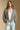 Front view of a woman wearing the Saltwater Luxe Aden Sweater on a neutral background with hands in pockets