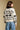 Back view of a woman wearing the Saltwater Luxe Alamere Sweater on a neutral background with jeans