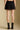 Back view of a woman wearing the Saltwater Luxe Andie Mini Skirt on a neutral background