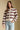 Front view of a woman wearing the Saltwater Luxe Arella Sweater on a neutral background with hand in pocket of jeans