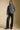 A full body front view of a woman wearing the Saltwater Luxe Arella Sweater on a neutral background