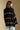 Back view of a woman wearing the Saltwater Luxe Birdy Sweater on a neutral background looking towards one shoulder