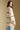 Back view of a woman wearing the Saltwater Luxe Birdy Sweater on a neutral background looking over one shoulder