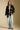 A full body front view of a woman wearing the Saltwater Luxe Birdy Sweater on a neutral background
