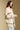 Side angle view of a woman wearing the Saltwater Luxe Birdy Sweater on a neutral background with hands clasped
