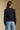 Back view of a woman wearing the Saltwater Luxe Verity Sweater on a neutral background with arms at sides